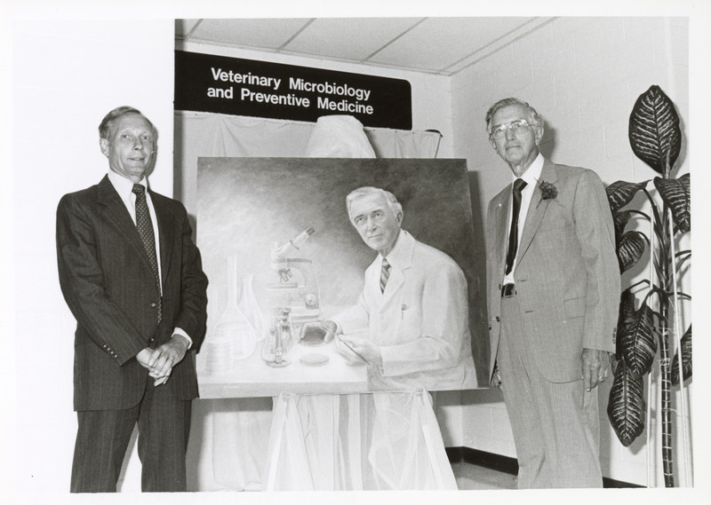 Photograph of R. Allen Packer and Dean Pearson at the dedication of Packer's portrait in the microbiology lobby