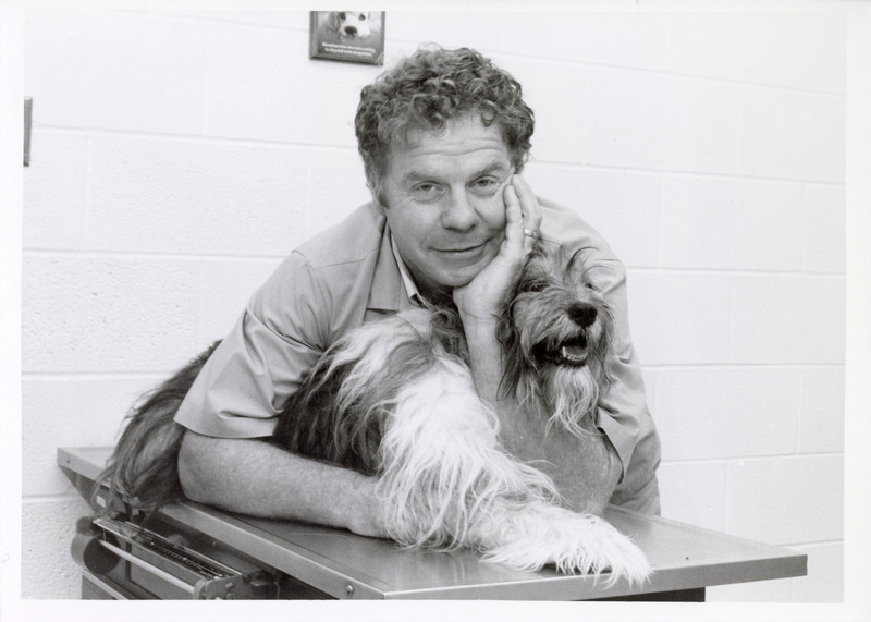 Photograph of Robert Carithers in the small animal clinic with a dog