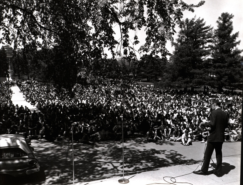 Photograph taken from the stairs of Curtis Hall, showing students attending an anti-war/pro-peace rally in response to the Kent State shooting. This rally took place before law enforcement or the Board of Regents began objecting to the nature of the protests.