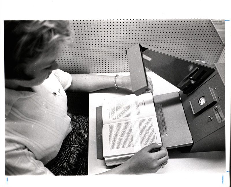 A photograph showing a student demonstrating a reading machine in the Pearson Hall reading lab.