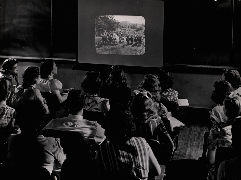 Photograph of students studying a projected image in a Iowa State University history classroom.