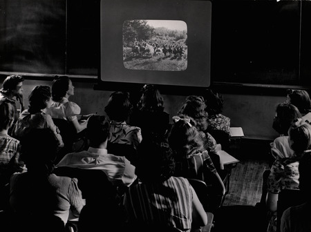 Photograph of students studying a projected image in a Iowa State University history classroom.