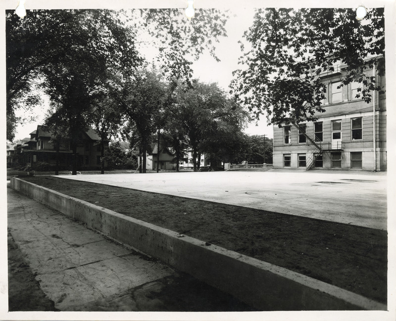 Photograph of a concrete tennis court and a retaining wall in Sloane Wallace School