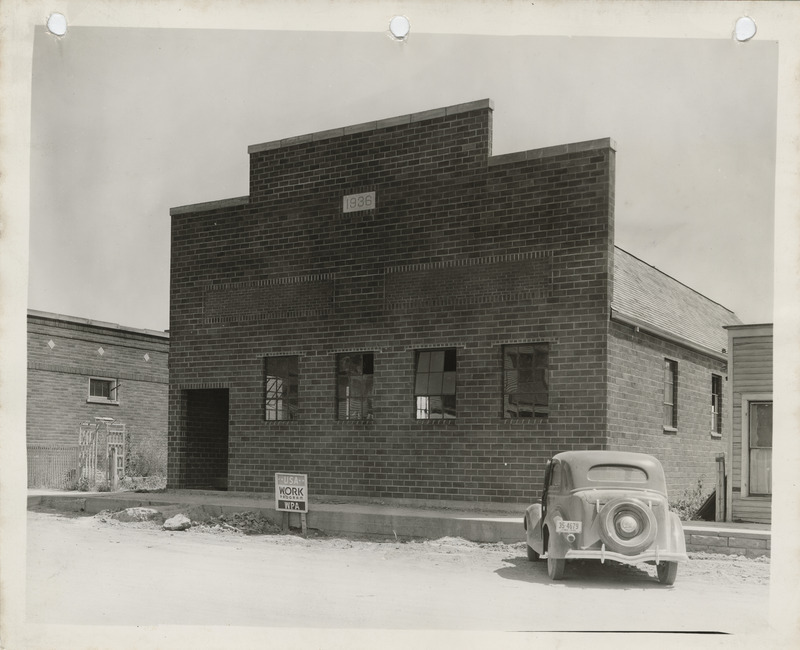 Photograph of a car parked in front of the Popejoy community house