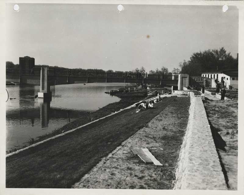 Photograph of people sitting on a levee in Iowa City