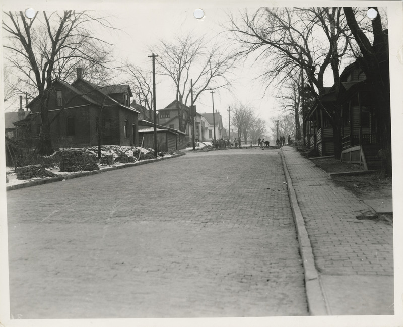 Photograph of people taking up paving and cleaning brick in Muscatine