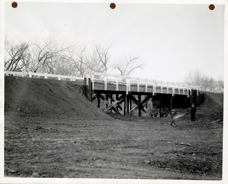 Photograph of people standing by a completed bridge on a state road in Guthrie County