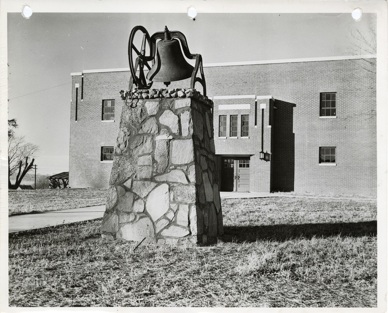 Photograph of the bell outside the high school gym in Panora