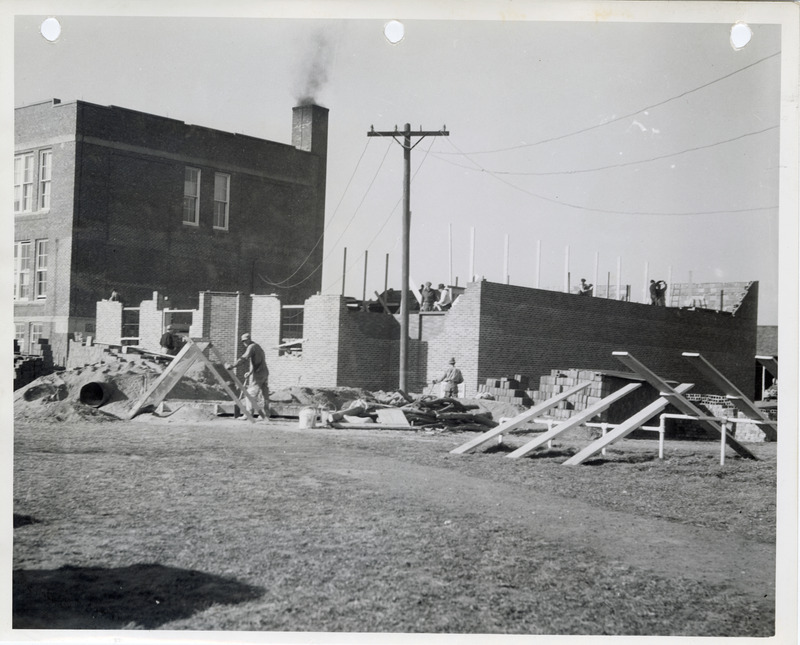 Photograph of people constructing the high school gym and auditorium in Cedar