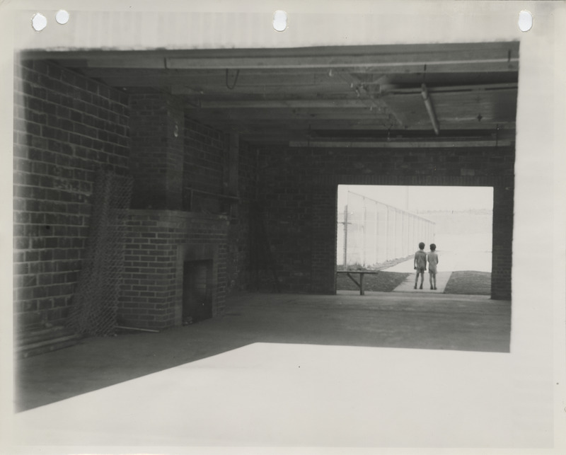 Photograph of two people standing outside a shelter house at a city park in Pella