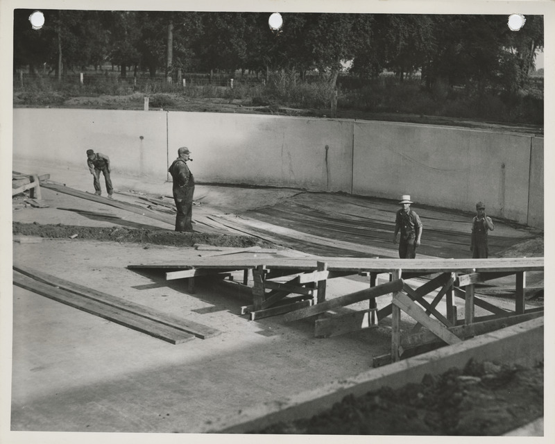 Photograph of people working on the south end of the swimming pool at Riverview Park in Marshalltown