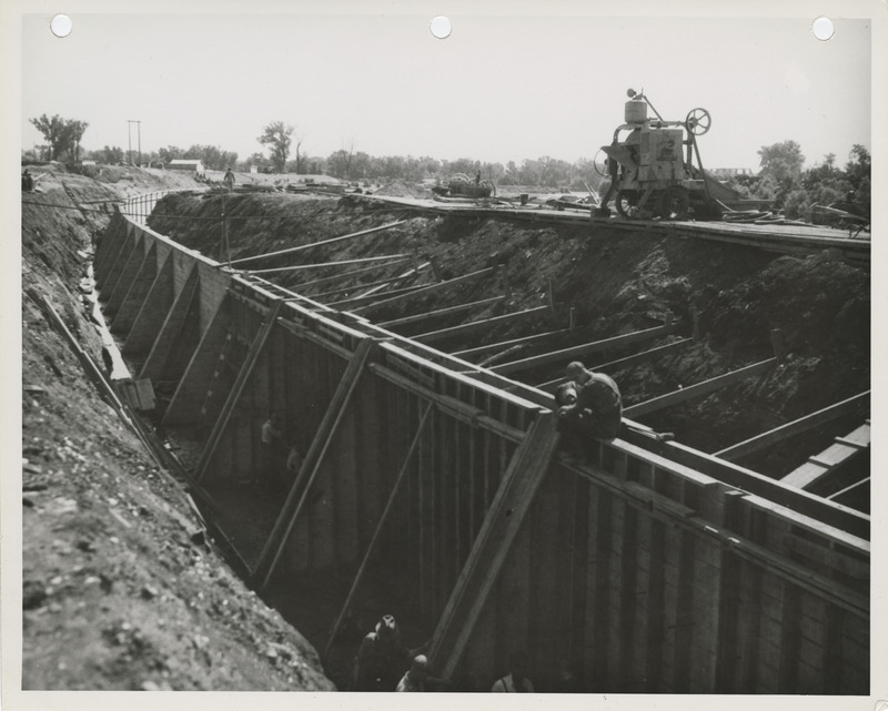 Photograph of people building forms for a river wall on the Raccoon River in Des Moines