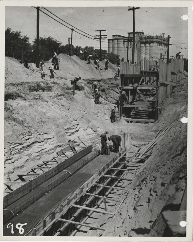 Photograph of people constructing a sanitary and storm sewer at E 20th and Walnut in Des Moines