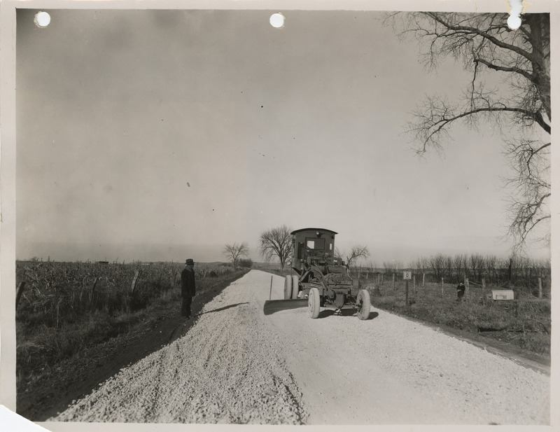 Photograph of a road grading machine working on crushed rock at the farm-to-market road in Glenwood