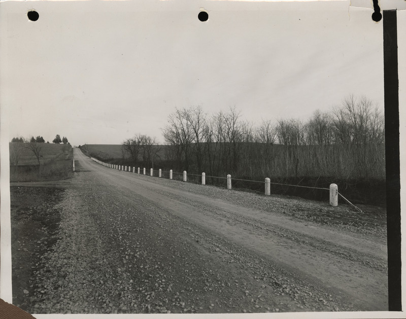 Photograph of farm-to-market road with guard rail and graveled road in Malvern