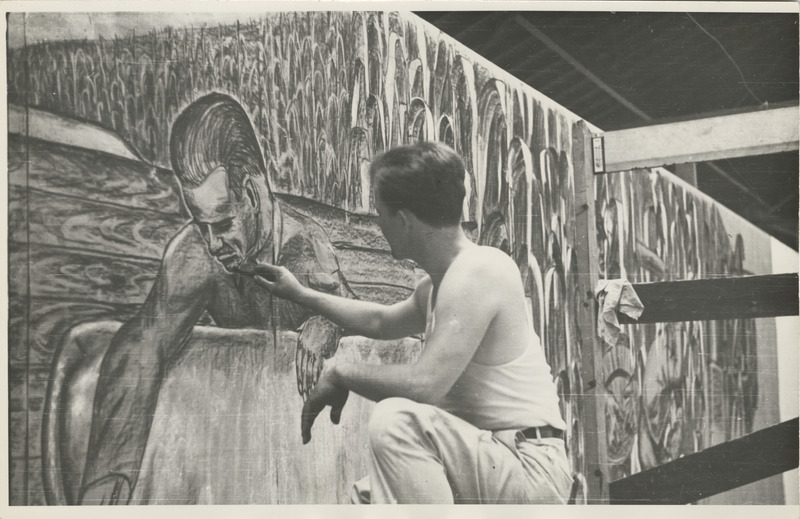 Photograph of a person painting a mural