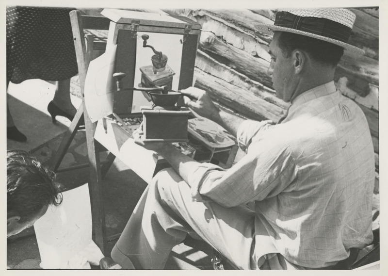 Photograph of a person painting an image of a hand crank grinder