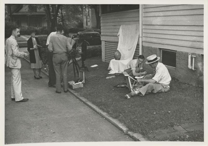Photograph of people around a vase