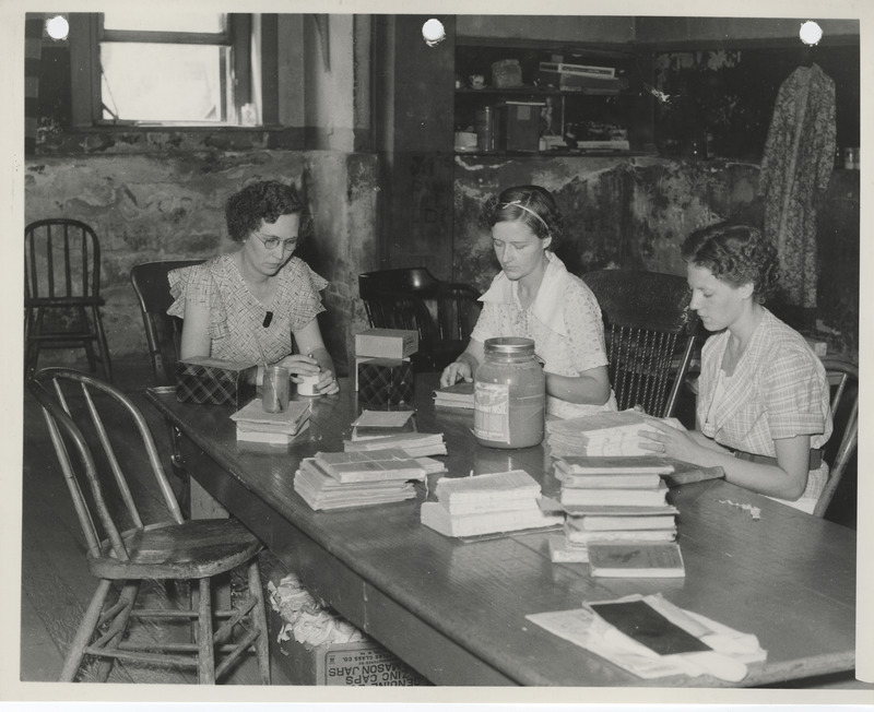 Photograph of people mending and indexing school books in Albia