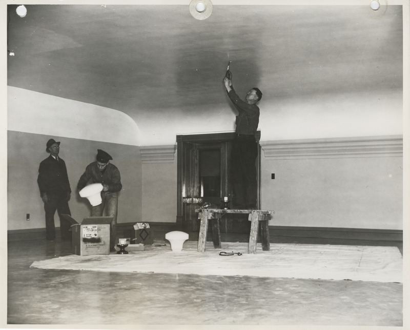 Photograph of people installing light fixtures at the county courthouse in Marshalltown
