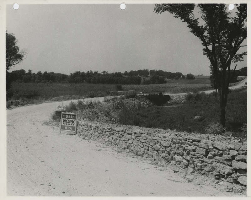Photograph of guard rails and riprapped bridge along the farm-to-market road in Cedar Rapids