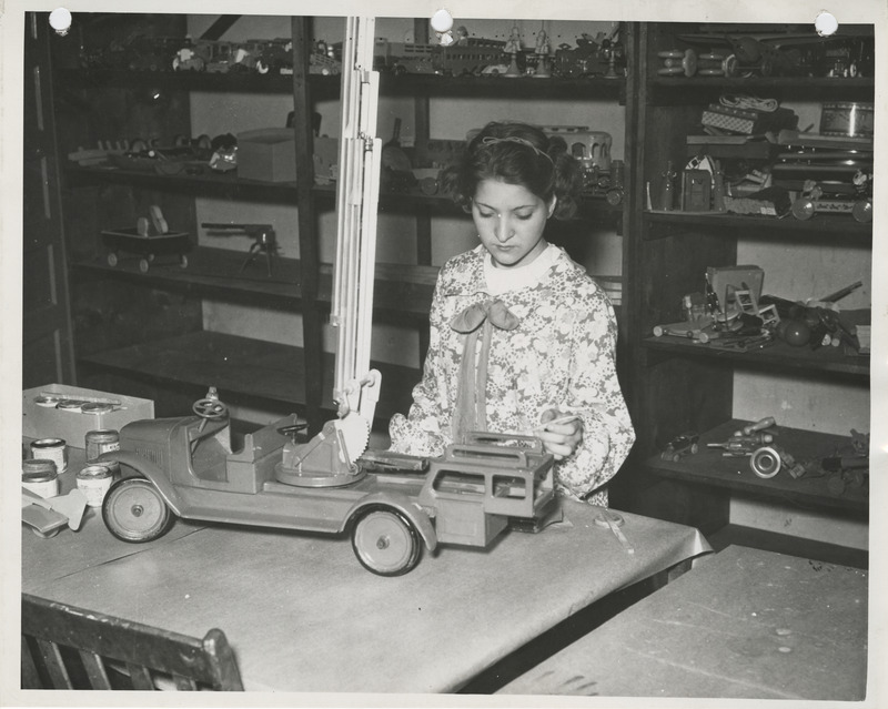 Photograph of a person painting a toy truck