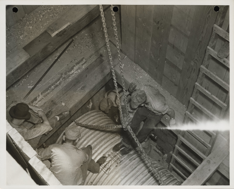 Photograph of people working on a sewer pipe in Webster City