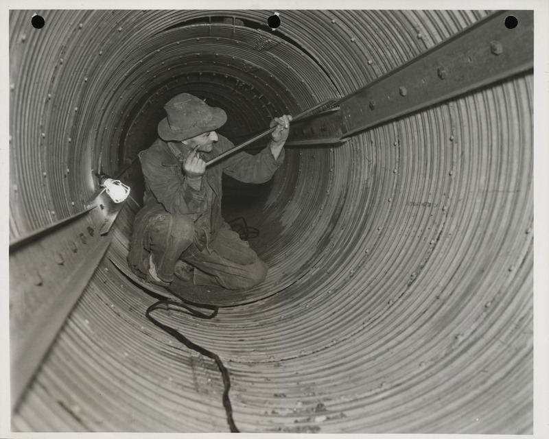 Photograph of a person working on a sewer pipe in Webster City