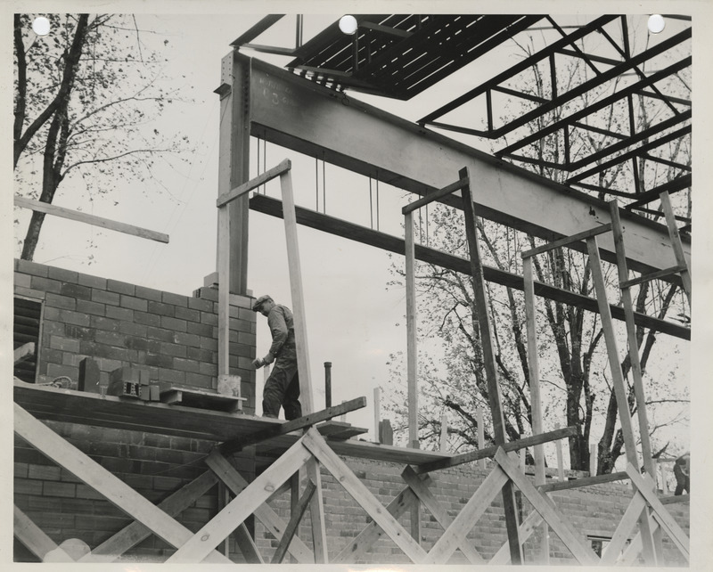 Photograph of a person working on a school building gymnasium addition in Durant
