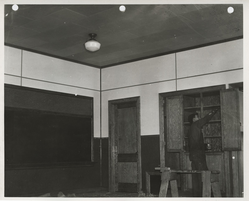 Photograph of a person painting cabinets at a school in Gillett Grove