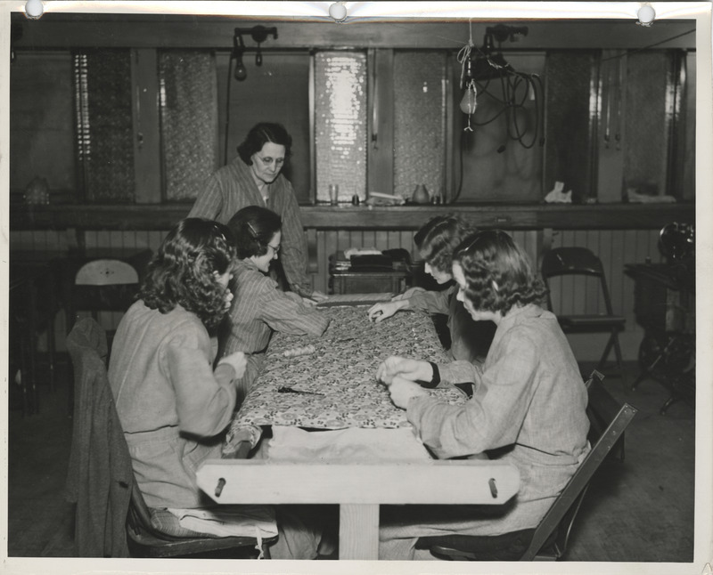 Photograph of people making quilts in a sewing room in Dubuque