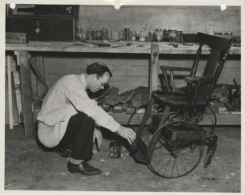Photograph of a person painting a wheelchair in Dubuque