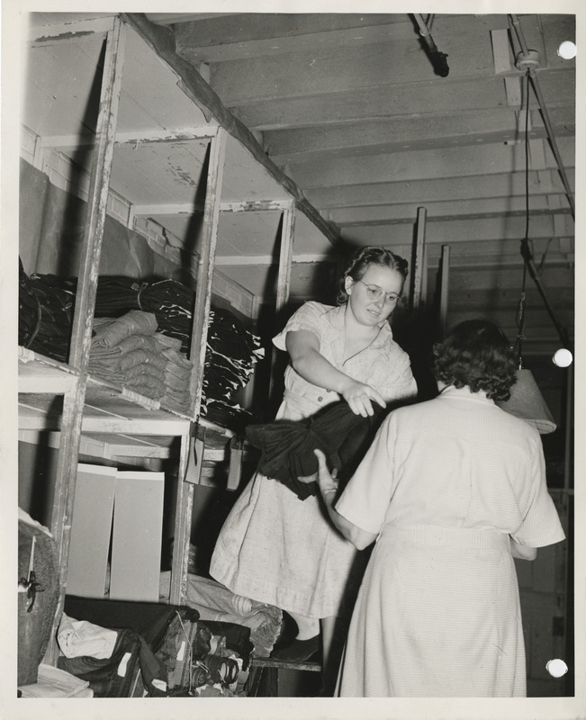 Photograph of women holding the fabric in the stock room in Davenport