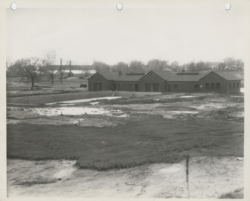 Photograph of the swimming pool and the bathhouse under construction at the city park in Pella.