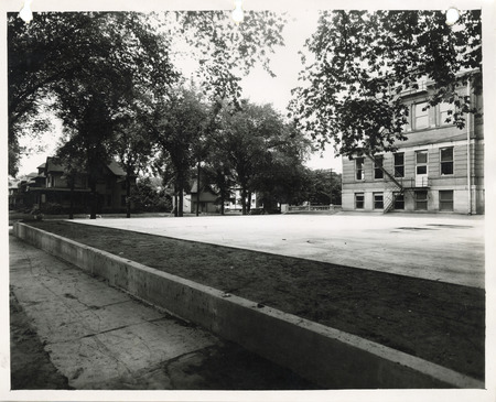 Photograph of a concrete tennis court and a retaining wall in Sloane Wallace School
