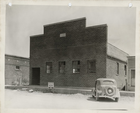 Photograph of a car parked in front of the Popejoy community house