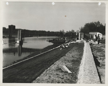 Photograph of people sitting on a levee in Iowa City
