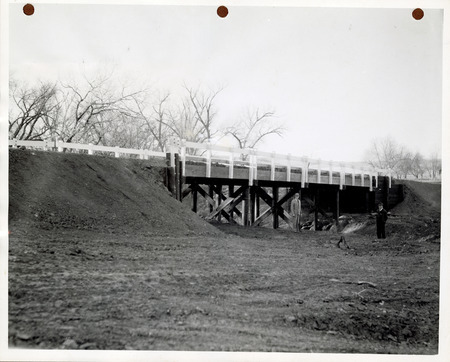 Photograph of people standing by a completed bridge on a state road in Guthrie County