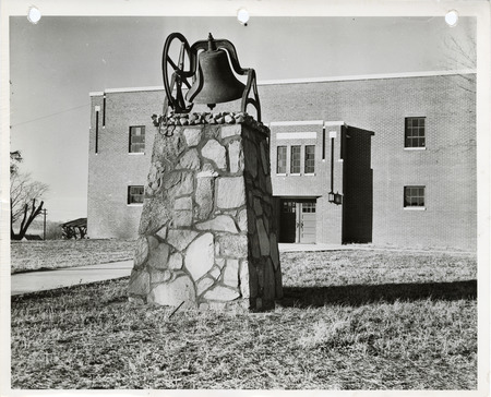 Photograph of the bell outside the high school gym in Panora