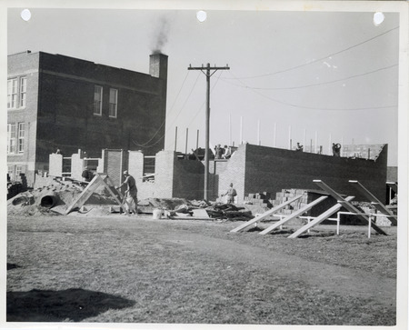 Photograph of people constructing the high school gym and auditorium in Cedar