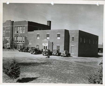 Photograph of cars parked outside the high school gym in Cedar