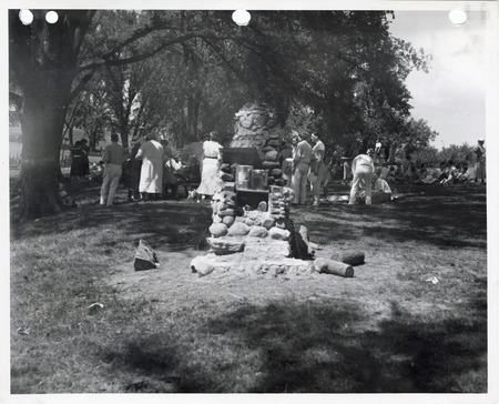 Photograph of people standing around an outdoor fireplace at Edmundson Park in Oskaloosa