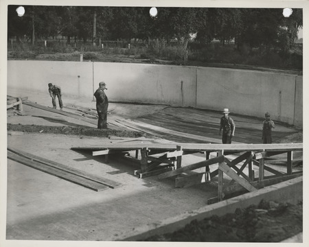Photograph of people working on the south end of the swimming pool at Riverview Park in Marshalltown