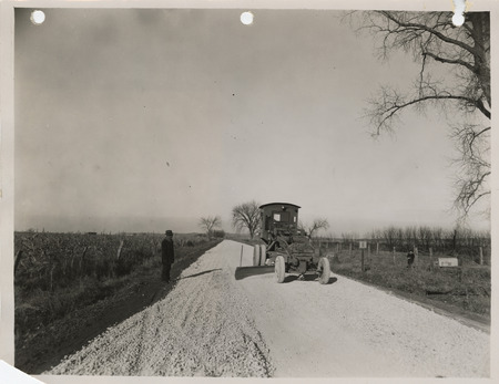 Photograph of a road grading machine working on crushed rock at the farm-to-market road in Glenwood