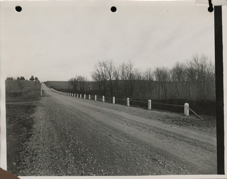 Photograph of farm-to-market road with guard rail and graveled road in Malvern