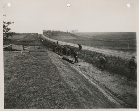 Photograph of people grubbing a road in Pottawattamie County