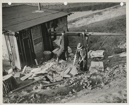 Photograph of people working outside a woodshed at the university campus in Iowa City