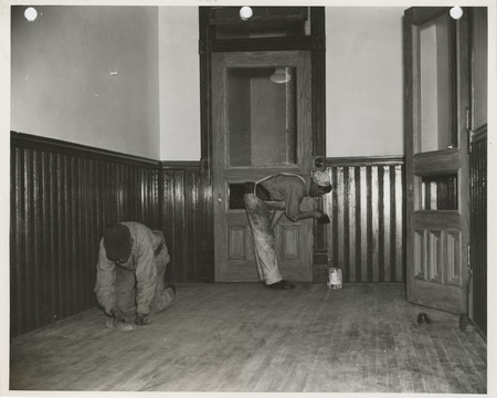 Photograph of people refinishing the wood paneling and floor of the county courthouse in Marshalltown
