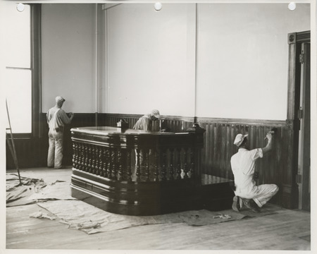 Photograph of people refinishing the wood paneling at the county courthouse in Marshalltown