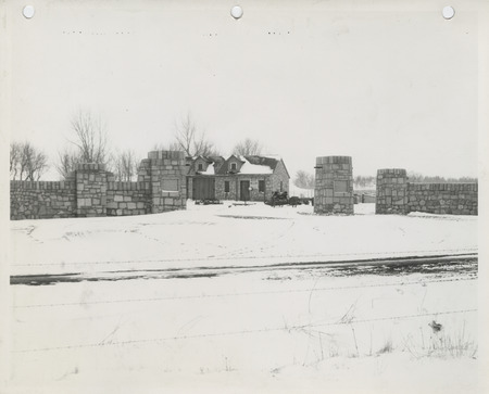 Photograph of a shelter house, fence, and gates at a park in Le Mars